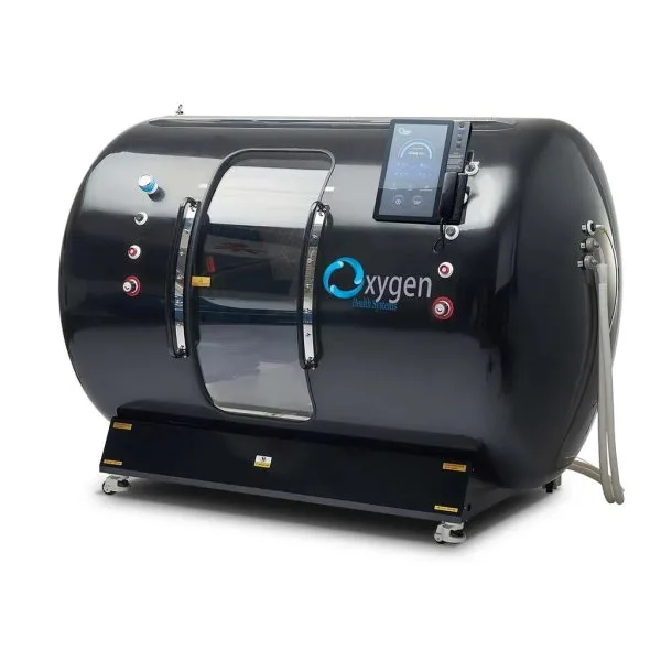Glossy black hyperbaric oxygen chamber with a side viewing window, mounted touchscreen control panel, and connection hoses on a wheeled base